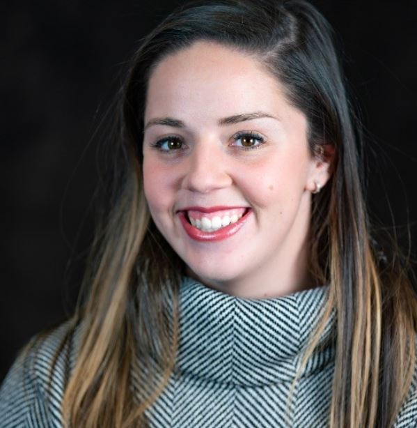Headshot of Michaela Rollins wearing a grey turtleneck sweater